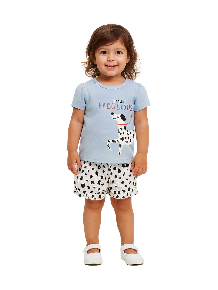 Conjunto para niña con camiseta azul estampada de un perro y shorts blancos con manchas negras.