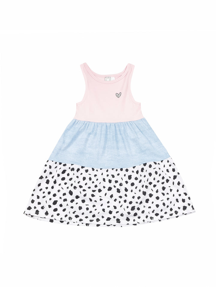 Niña pequeña vistiendo un vestido tricolor en rosa, azul y blanco con puntos negros.