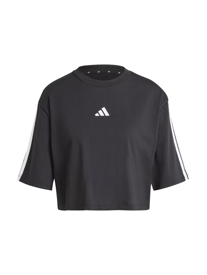 Mujer vistiendo playera holgada negra de algodón Adidas con rayas blancas en las mangas.