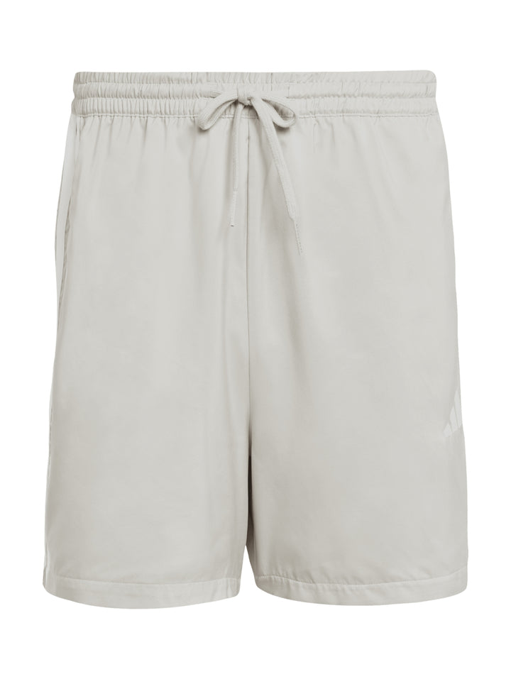 Shorts deportivos Adidas color beige con tres rayas blancas laterales y logo frontal.