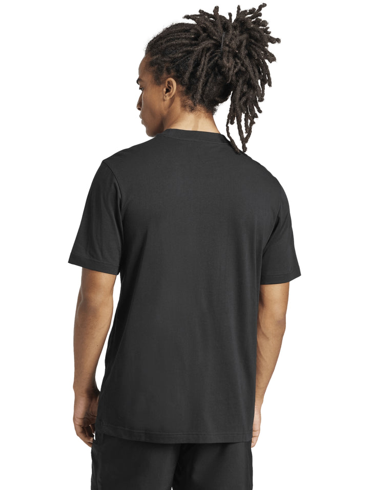 Hombre vistiendo playera negra de manga corta con logo pequeño de Adidas en el pecho.