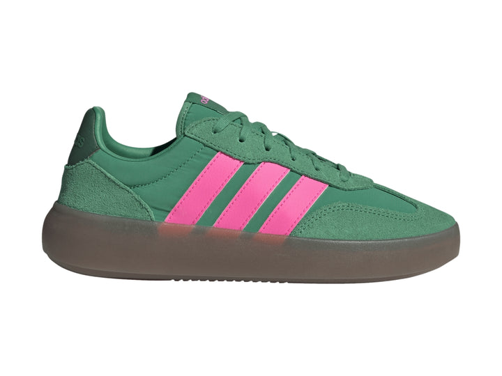 Tenis Adidas color verde con tres franjas rosas laterales y suela gris oscuro.