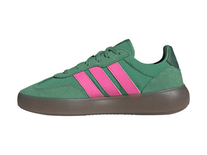 Tenis Adidas color verde con tres franjas rosas laterales y suela gris oscuro.