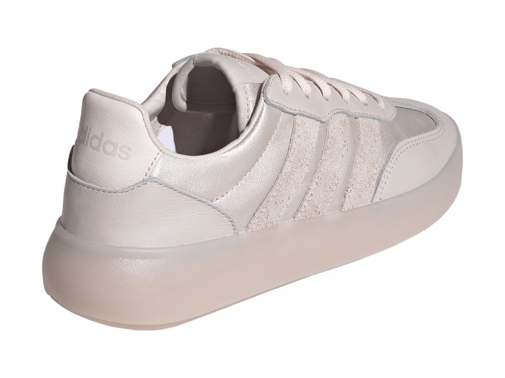 Tenis Adidas color rosa metálico con suela gruesa y tres franjas laterales.