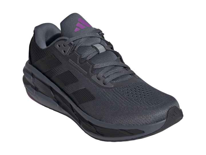 Tenis deportivos Adidas Questar 3 en color gris granito y negro con detalle púrpura en la suela.