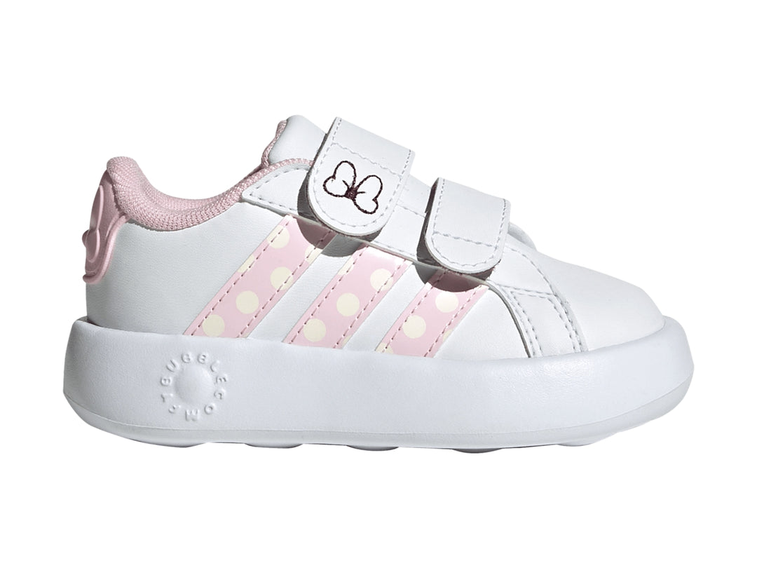 Tenis blancos Adidas para niña con detalles en rosa, rayas de lunares y un moño en la correa.