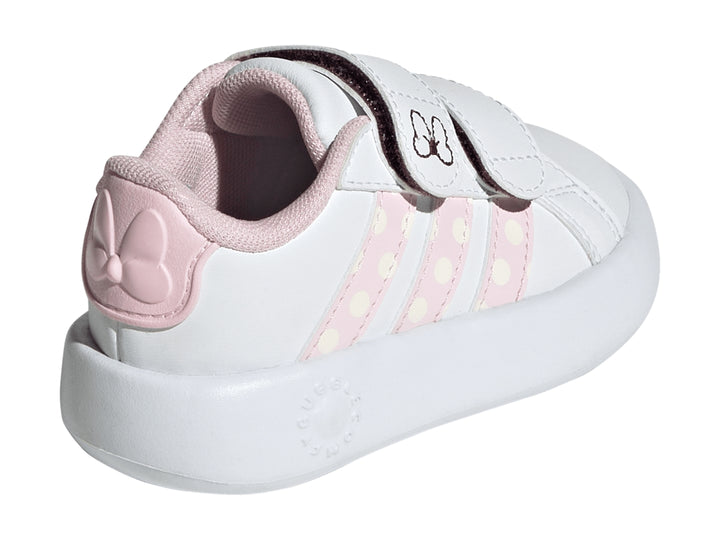 Tenis blancos Adidas para niña con detalles en rosa, rayas de lunares y un moño en la correa.
