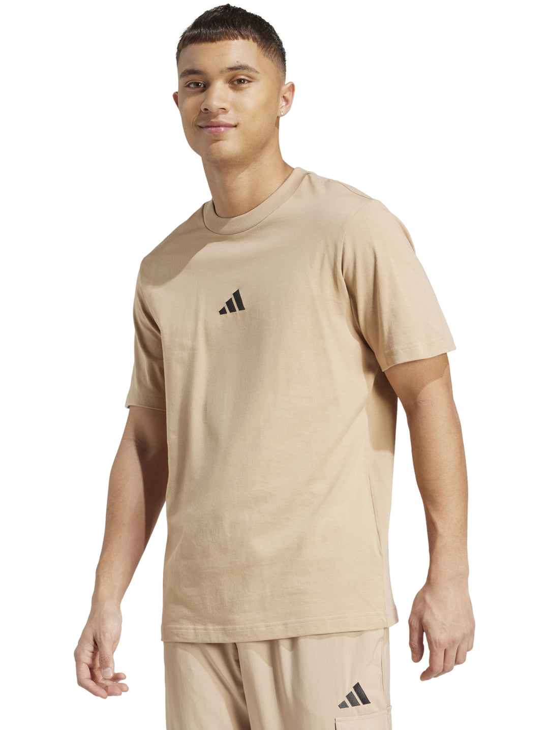 Hombre vistiendo playera Adidas color arena con logo negro en el pecho.