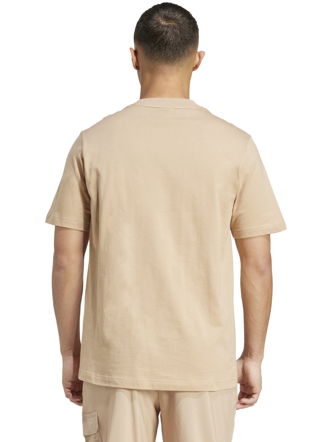 Hombre vistiendo playera Adidas color arena con logo negro en el pecho.