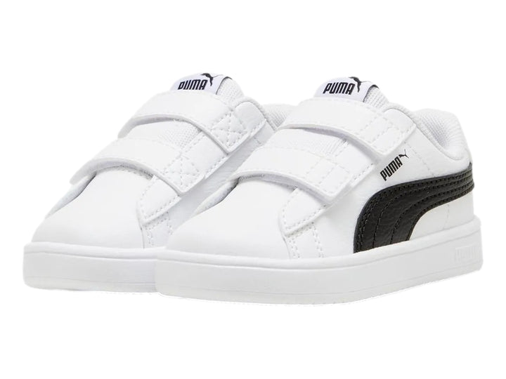 Tenis PUMA blancos para niño con franja negra lateral y cierre de velcro.