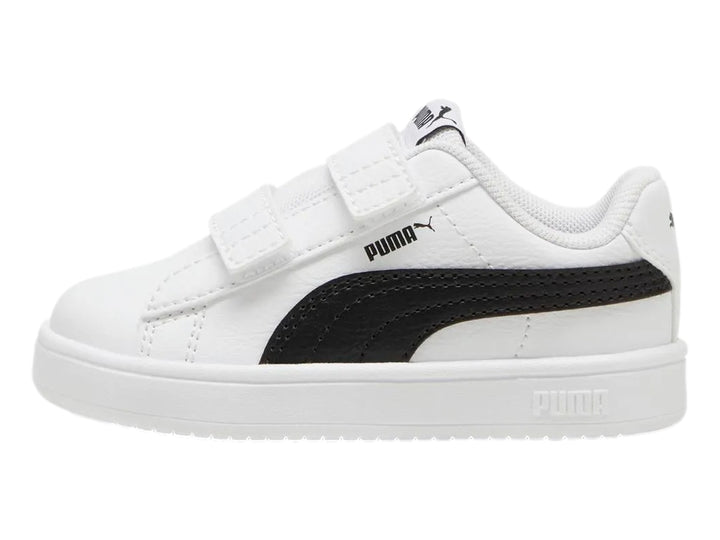 Tenis PUMA blancos para niño con franja negra lateral y cierre de velcro.