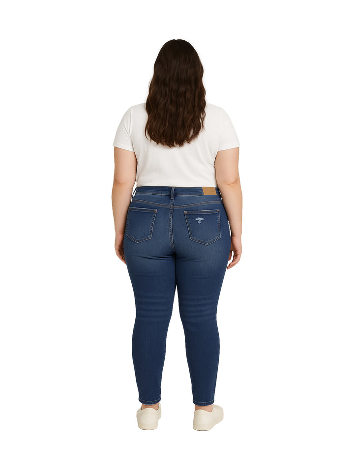 Mujer vistiendo pantalones skinny jeans de color azul oscuro con detalles desgastados.