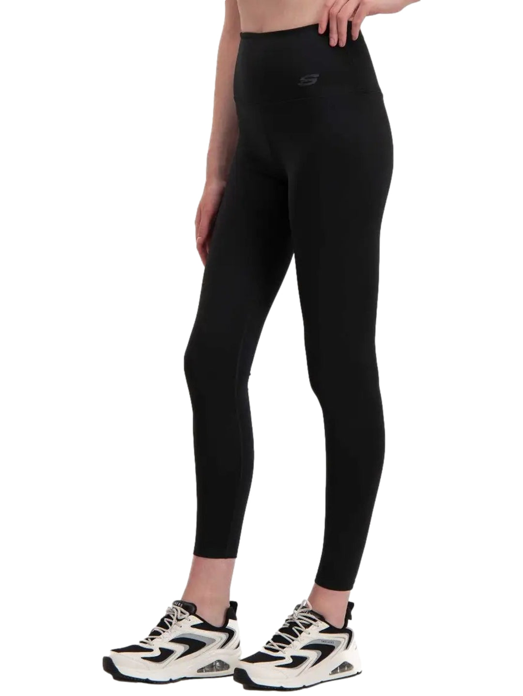 Mujer vistiendo leggings deportivos de color negro marca Skechers, ajustados al cuerpo y de talle alto.