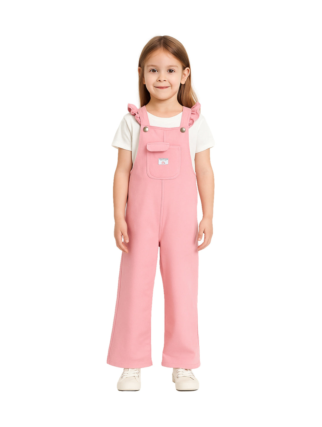 Niña vistiendo un overol color rosa de tirantes con camiseta blanca sobre fondo blanco.