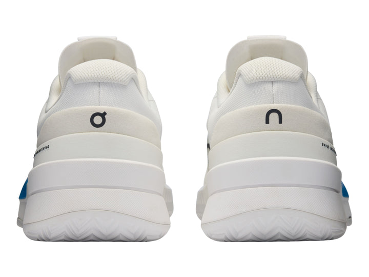 Tenis blancos On Cloud con detalle degradado en azul y rosa y logo negro en el lateral.