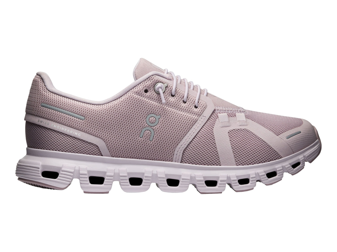Tenis deportivos On Cloud color malva con suela blanca y malla transpirable.