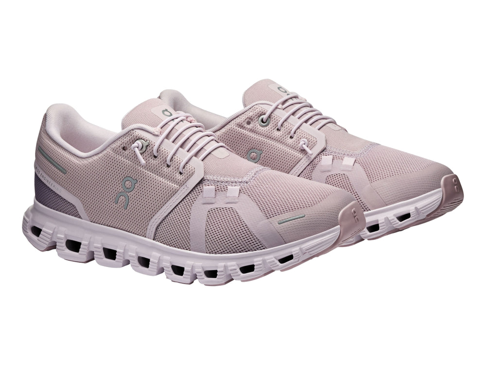 Tenis deportivos On Cloud color malva con suela blanca y malla transpirable.
