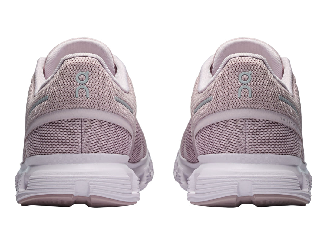 Tenis deportivos On Cloud color malva con suela blanca y malla transpirable.