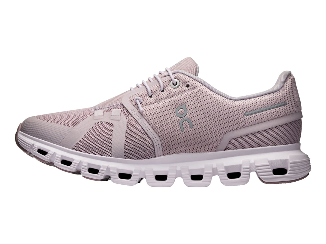 Tenis deportivos On Cloud color malva con suela blanca y malla transpirable.