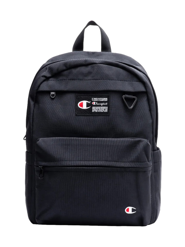 Mochila escolar Champion de color negro con bolsillo frontal y logotipos de la marca.