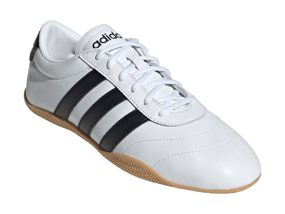 Tenis Adidas Grand Court Lo en color blanco con tres franjas negras y suela de goma color caramelo.