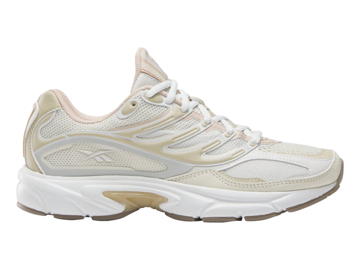 Tenis deportivo Reebok en color gris claro y blanco con detalles en beige y suela blanca.