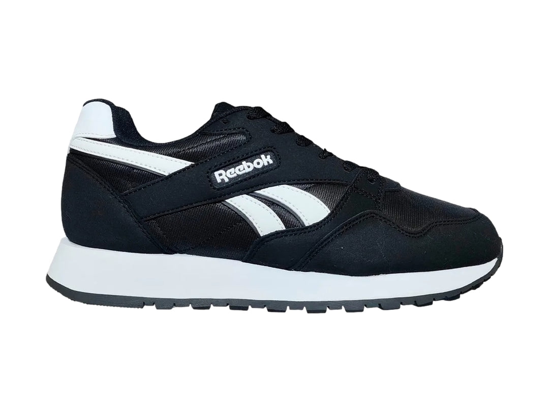 Tenis deportivos Reebok color negro con suela y detalles laterales en blanco.