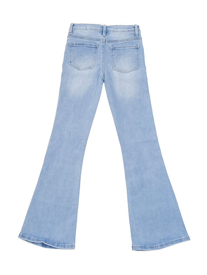 Niña vistiendo pantalones jeans azul claro estilo boot cut y playera blanca.