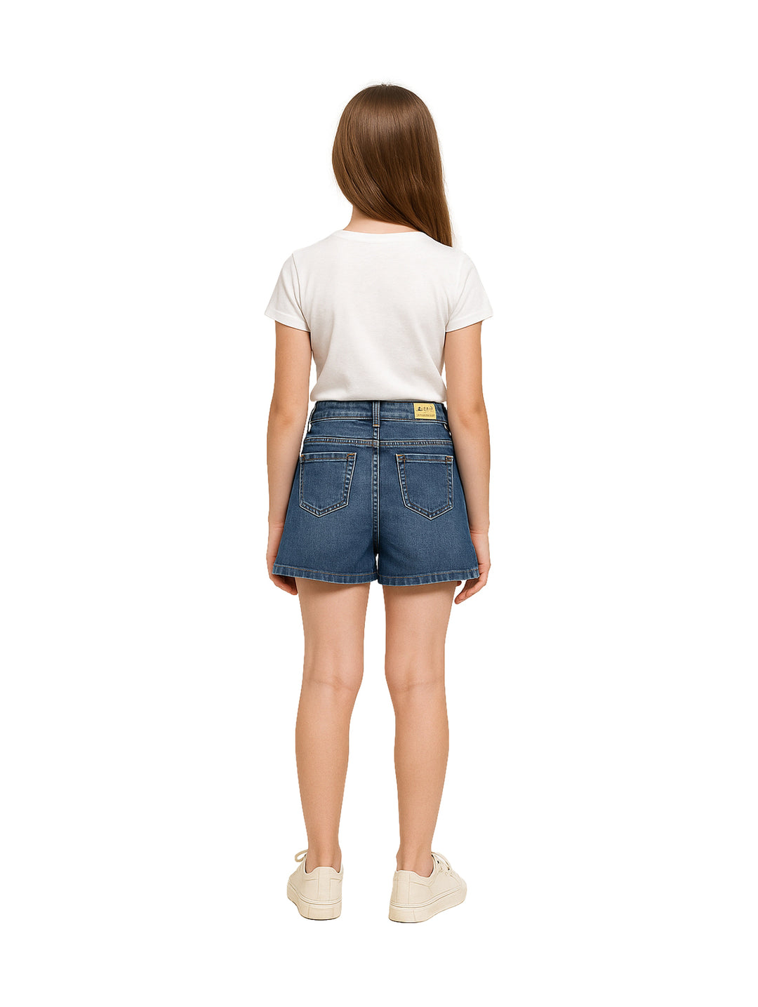 Niña vistiendo una falda corta de mezclilla azul con botones frontales y camiseta blanca.