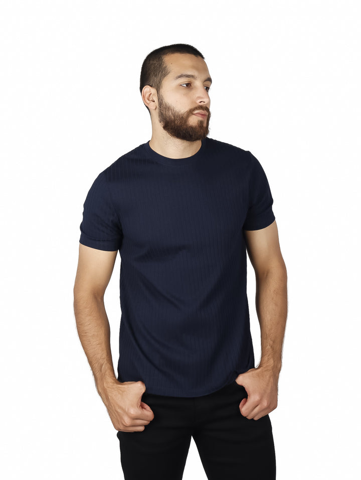 Hombre vistiendo camiseta de manga corta color azul oscuro con textura de rayas verticales.