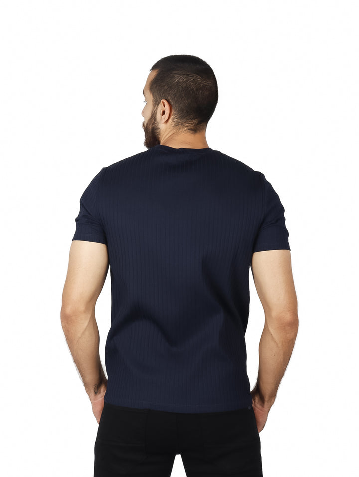 Hombre vistiendo camiseta de manga corta color azul oscuro con textura de rayas verticales.