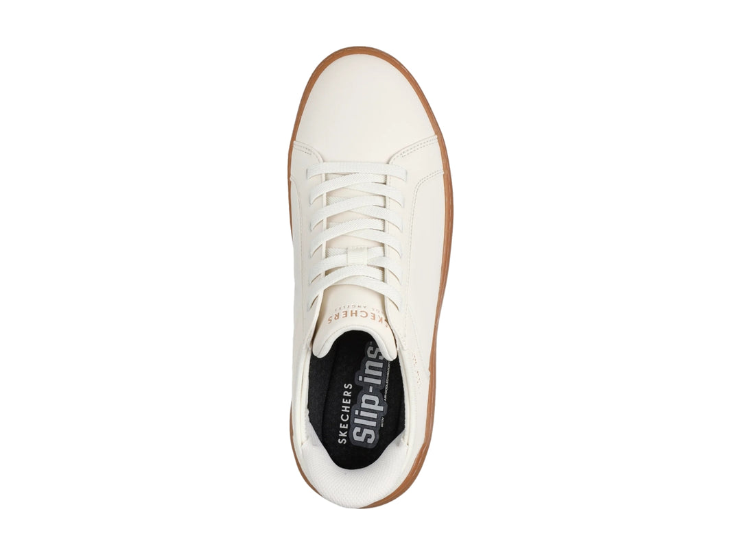 Tenis Skechers blancos con suela de goma color café y agujetas blancas.