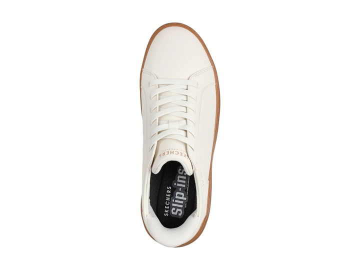 Tenis Skechers blancos con suela de goma color café y agujetas blancas.