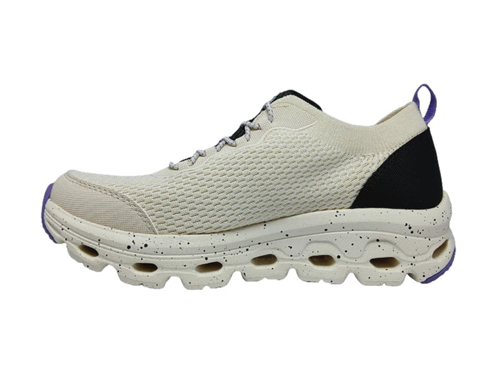 Tenis deportivos Skechers blancos con talón negro y suela blanca con detalles morados.