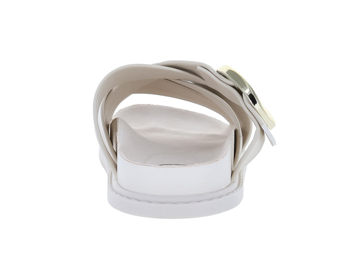Sandalia blanca para niña con correas cruzadas y una hebilla dorada decorativa en la parte superior.