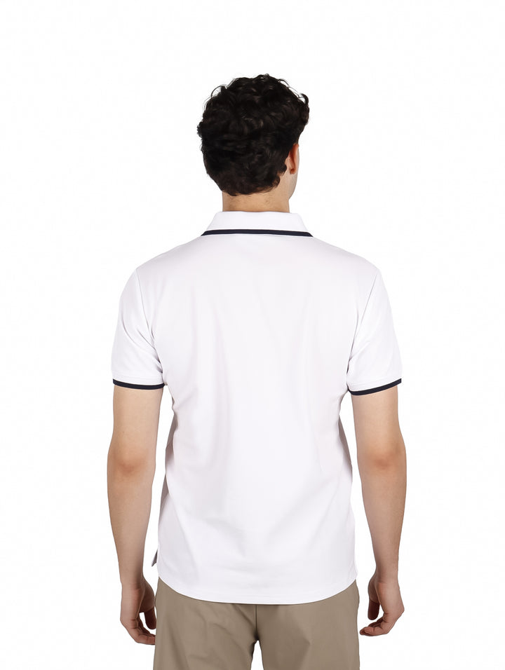 Hombre vistiendo una playera polo blanca de manga corta con detalles oscuros en el cuello y mangas.