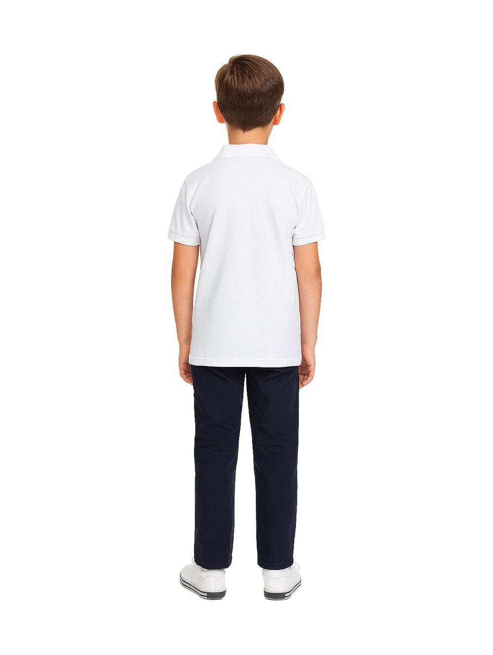 Niño modelando una playera polo blanca de manga corta con pantalones azul marino y tenis blancos.