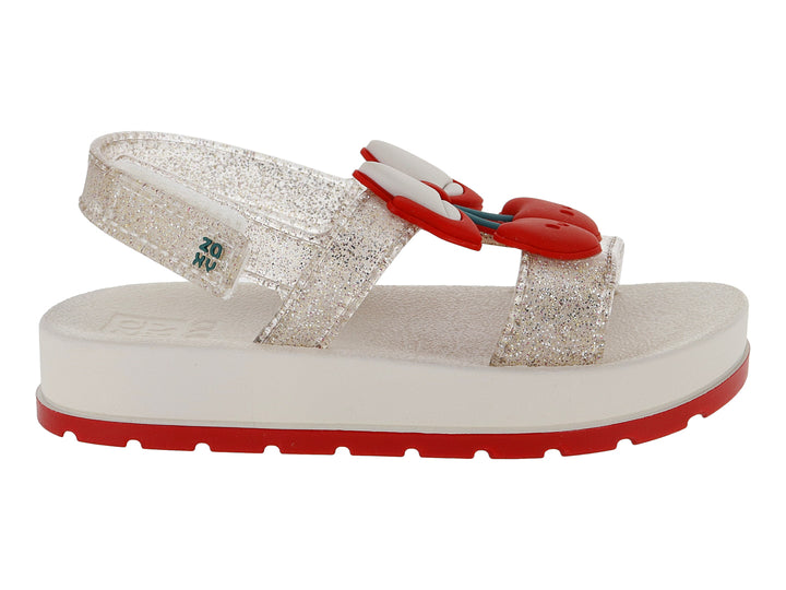 Sandalias blancas para niña con acabado brillante, plataforma blanca y suela roja con detalle decorativo rojo.