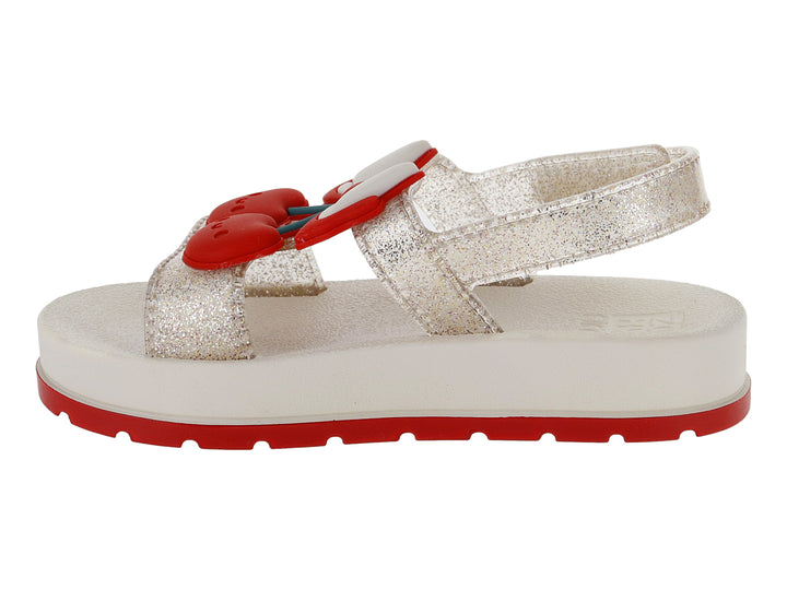 Sandalias blancas para niña con acabado brillante, plataforma blanca y suela roja con detalle decorativo rojo.