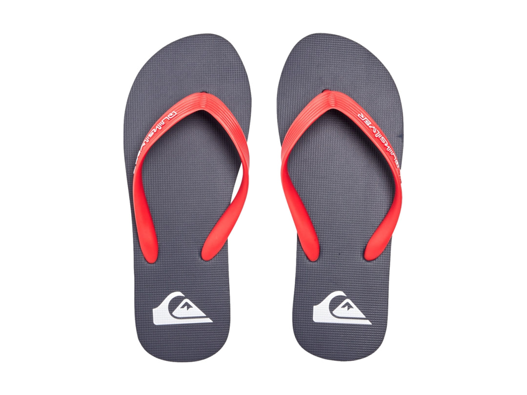 Sandalias Quiksilver color azul marino con correas rojas y suela plana.
