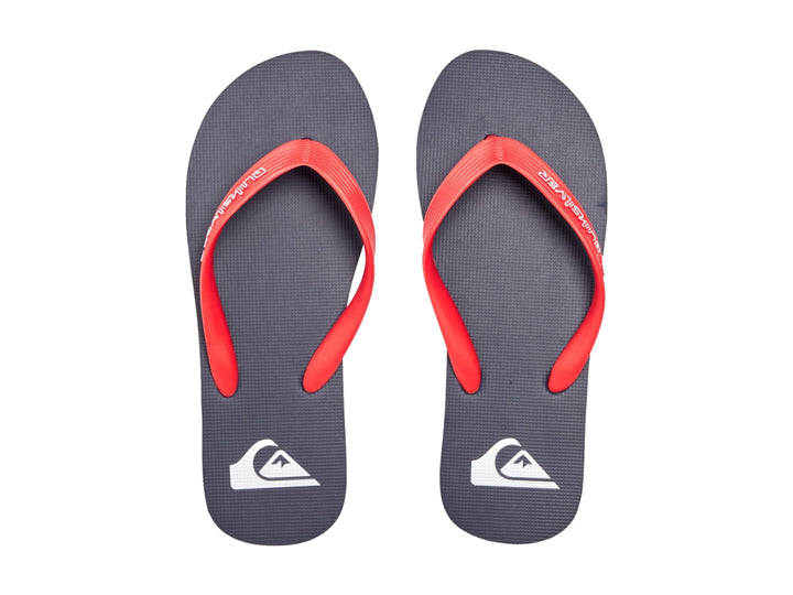 Sandalias Quiksilver color azul marino con correas rojas y suela plana.