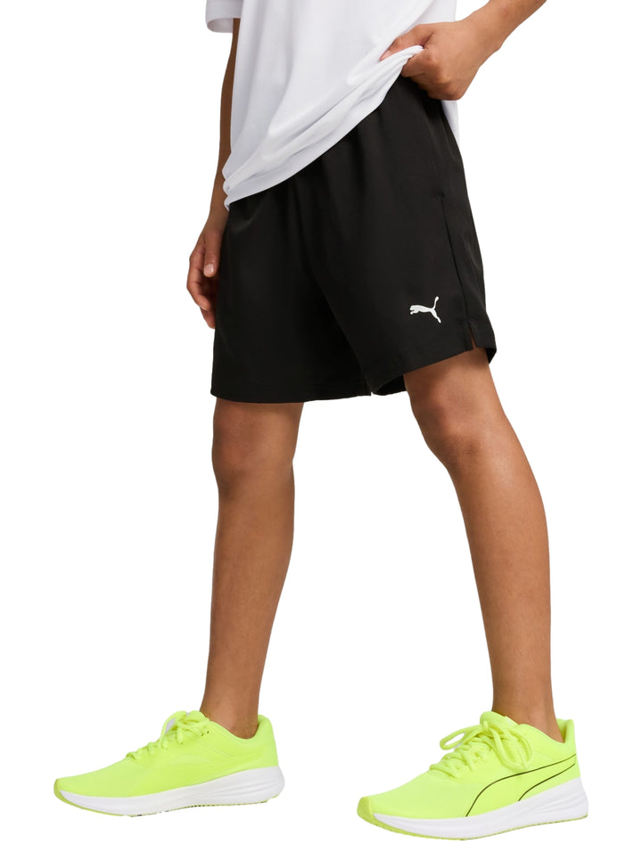 Niño vistiendo shorts deportivos Puma de color negro con logo blanco lateral.