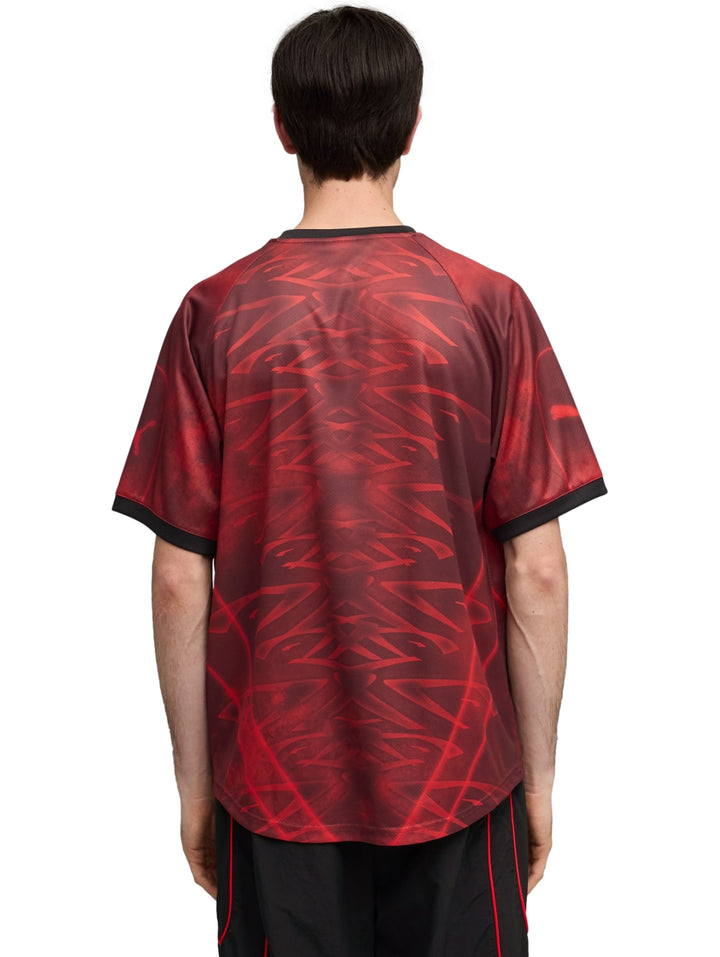 Jersey de fútbol PUMA color rojo con estampado abstracto y detalles en negro.
