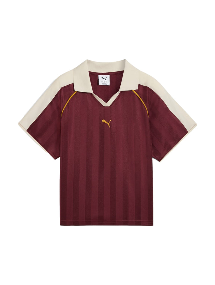 Mujer vistiendo playera y shorts deportivos PUMA en color ruby shimmer heather con detalles en blanco y dorado.