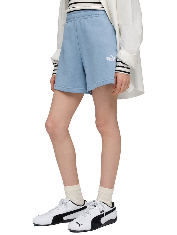 Niña usando shorts deportivos Puma color azul claro con logo blanco en la pierna.