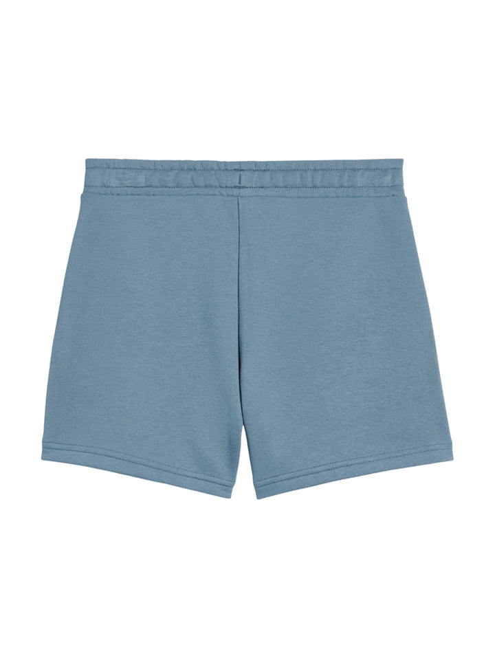 Niña usando shorts deportivos Puma color azul claro con logo blanco en la pierna.