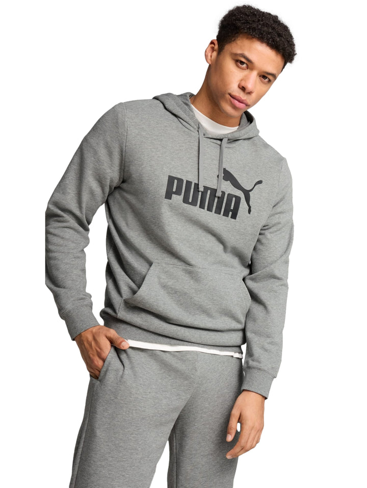 Hombre vistiendo sudadera con capucha y pantalones deportivos de color gris con logo de PUMA en el pecho.
