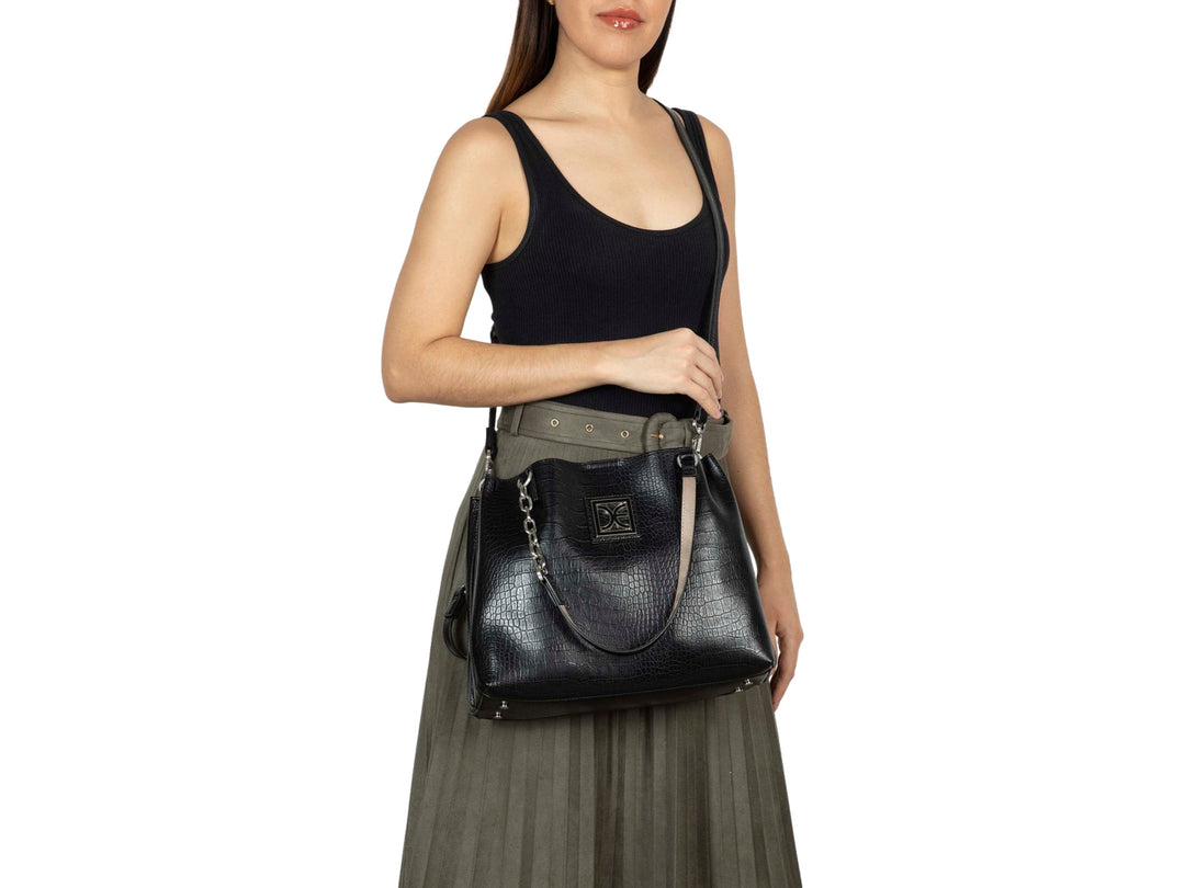 Bolso negro Cloe con textura de cocodrilo, asa con cadena plateada y logotipo metálico frontal.