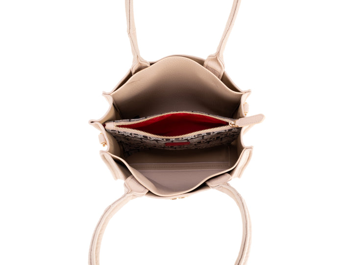 Bolso de hombro Cloe en color nude, con asas superiores y correa larga ajustable, diseño elegante y liso.