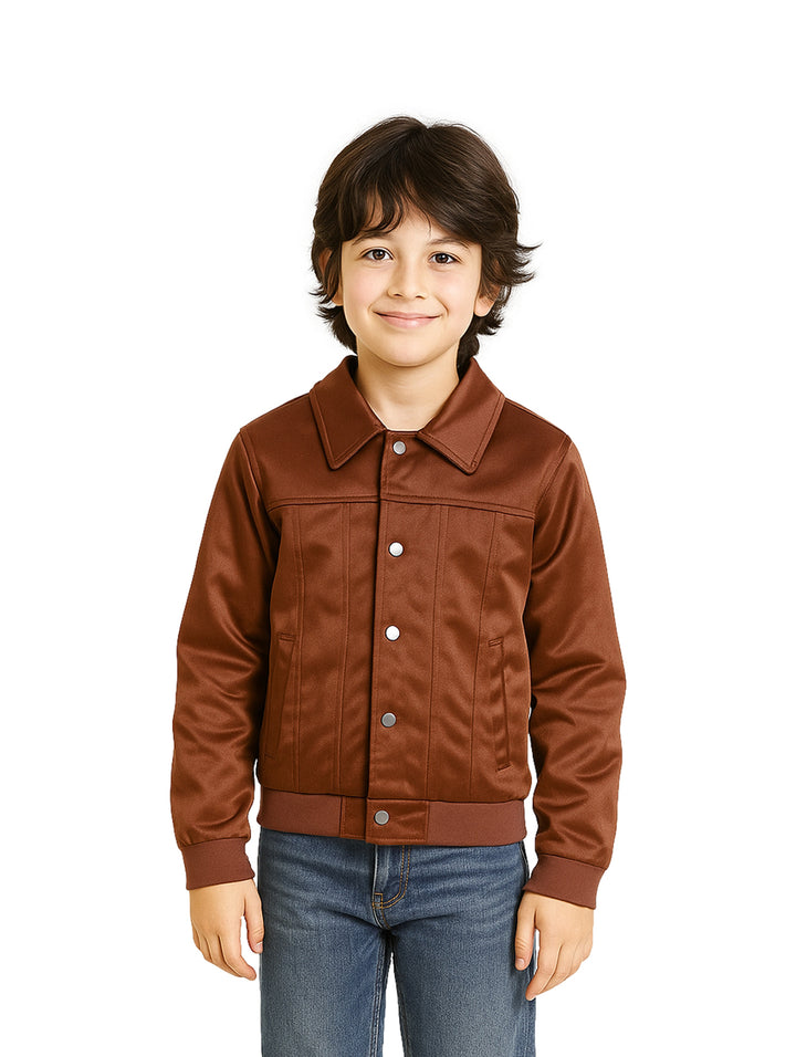 Niño vistiendo una chamarra color chocolate de la marca Pentagon con botones frontales y puños elásticos.